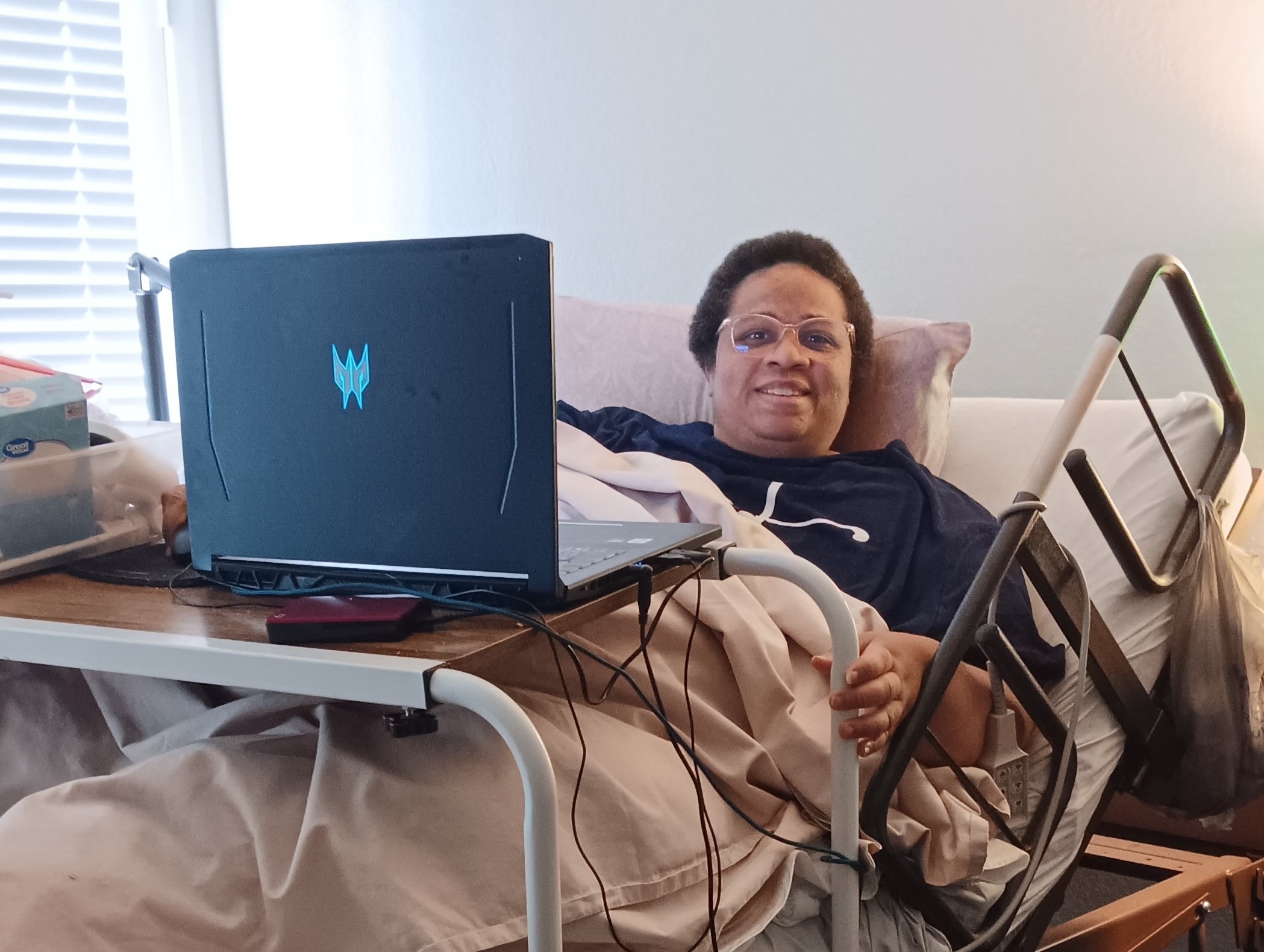 Misty in her bed smiling at the camera